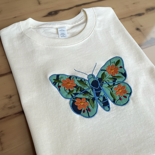 T-shirt color hueso con bordado de mariposa y flores – Colección Insectarium de Hilo Negro
